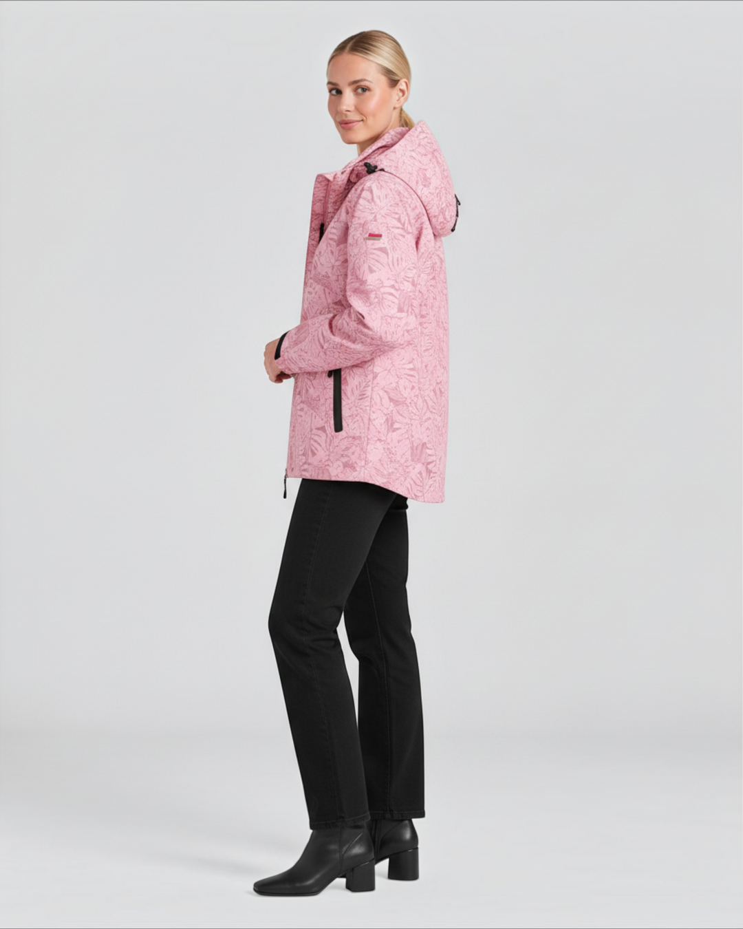 Luna Moda pink hooded waterproof jacket with leaf pattern worn by a model with black trousers and boots