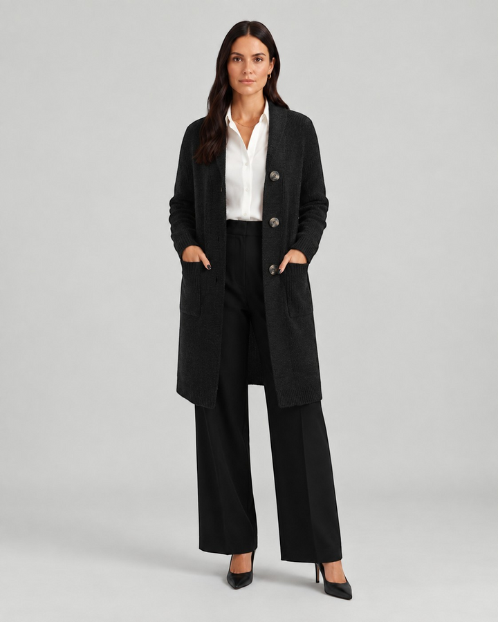 Luna Moda Chiara long black knit cardigan with front buttons and pockets worn over a white shirt and black trousers