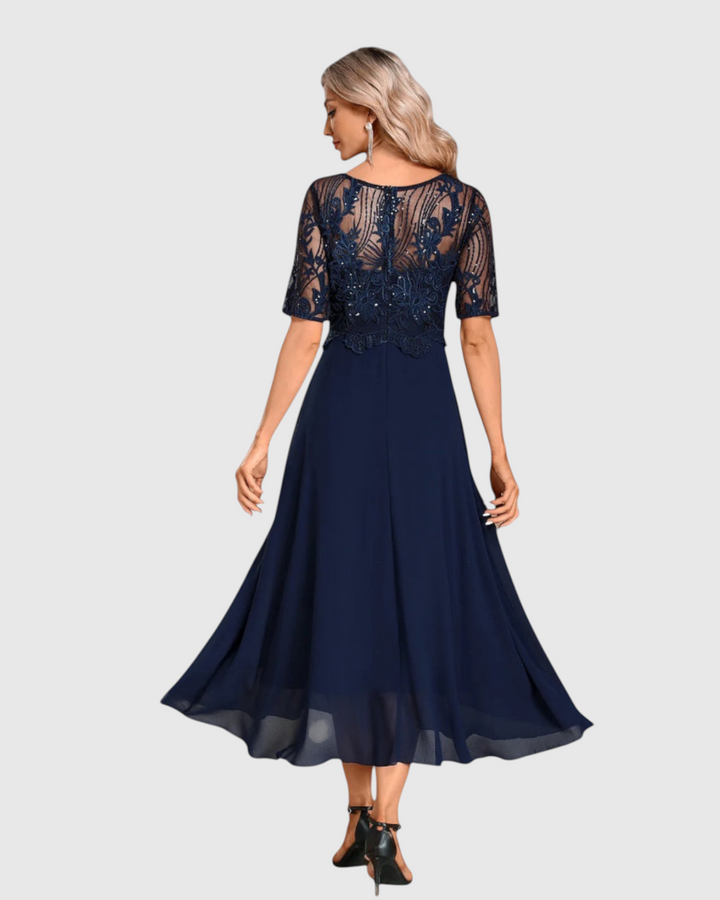 Luna Moda navy blue midi lace dress with short sleeves and a flowing skirt, shown from the back on a model.