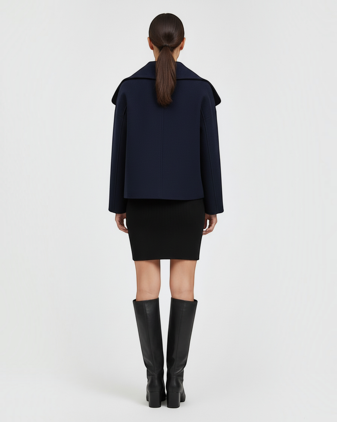 Back view of a model wearing a Luna Moda navy blue double-breasted mid-season coat with a wide collar.