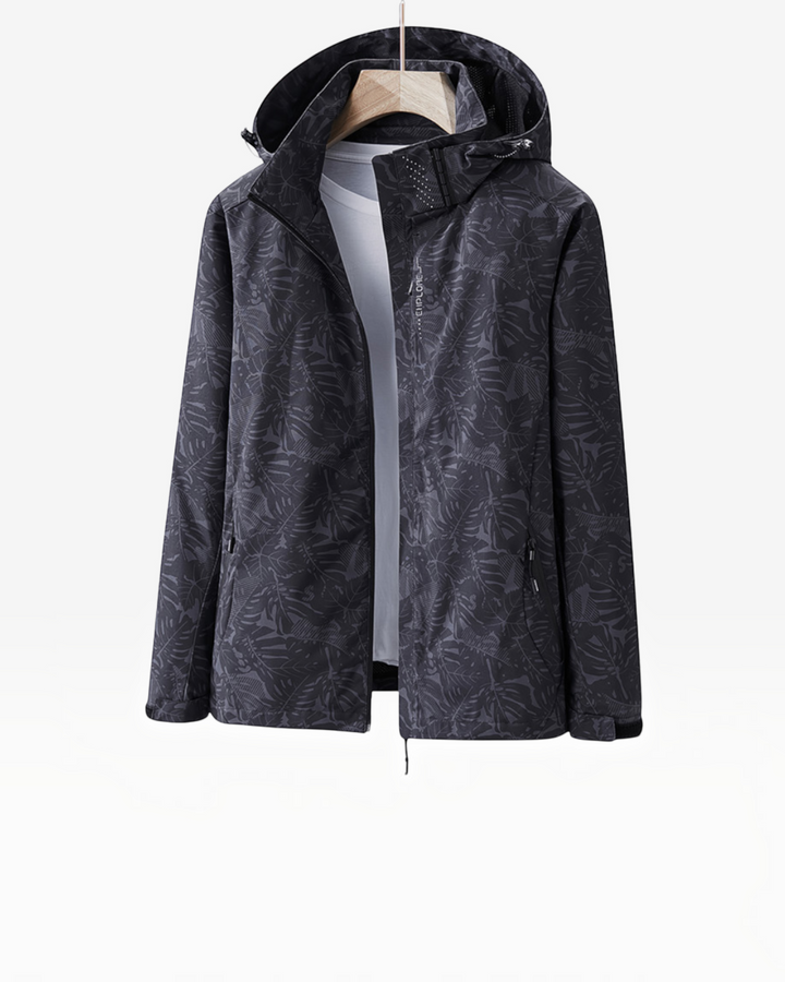 Luna Moda Eufemia lightweight waterproof hooded jacket in black with a subtle tropical leaf pattern on a hanger