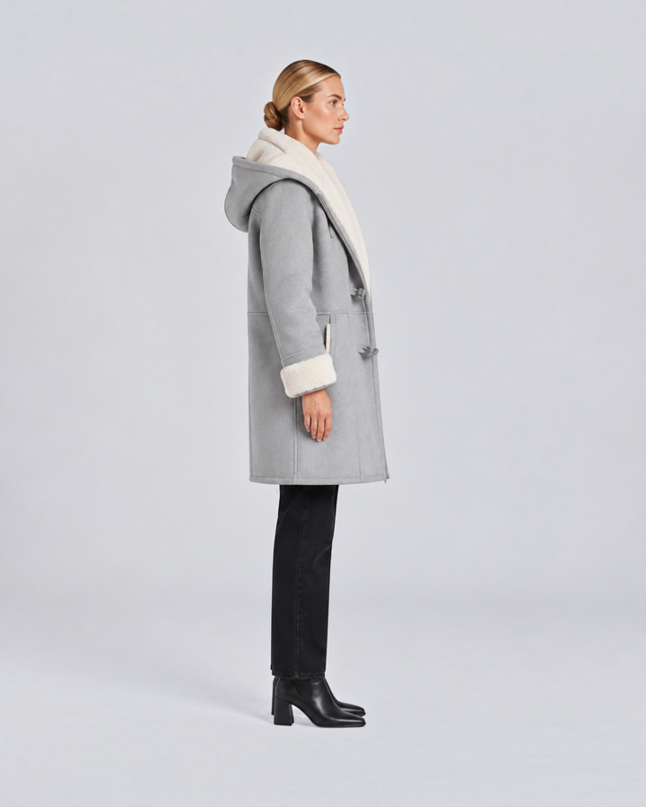 Luna Moda Antonia grey hooded winter coat with white faux fur lining and toggle closures worn by a woman side view