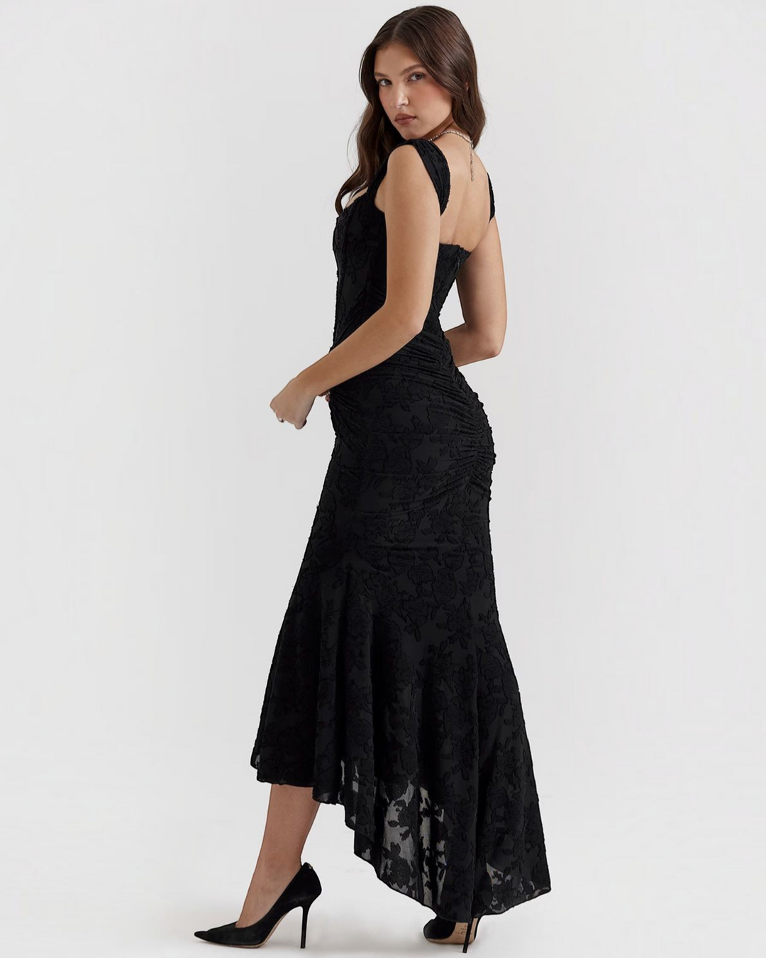 Luna Moda Katerina black floral midi dress with a corset bodice, ruched waist, and high-low hem on a model.