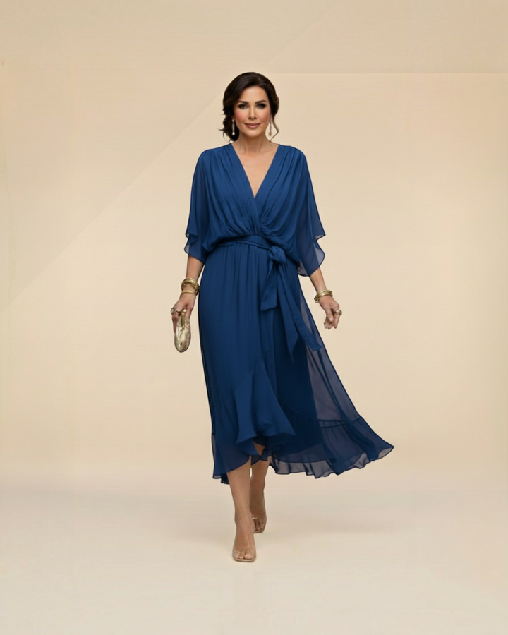 Luna Moda Monica blue chiffon midi dress with V-neck and tie waist worn by a woman on a neutral background