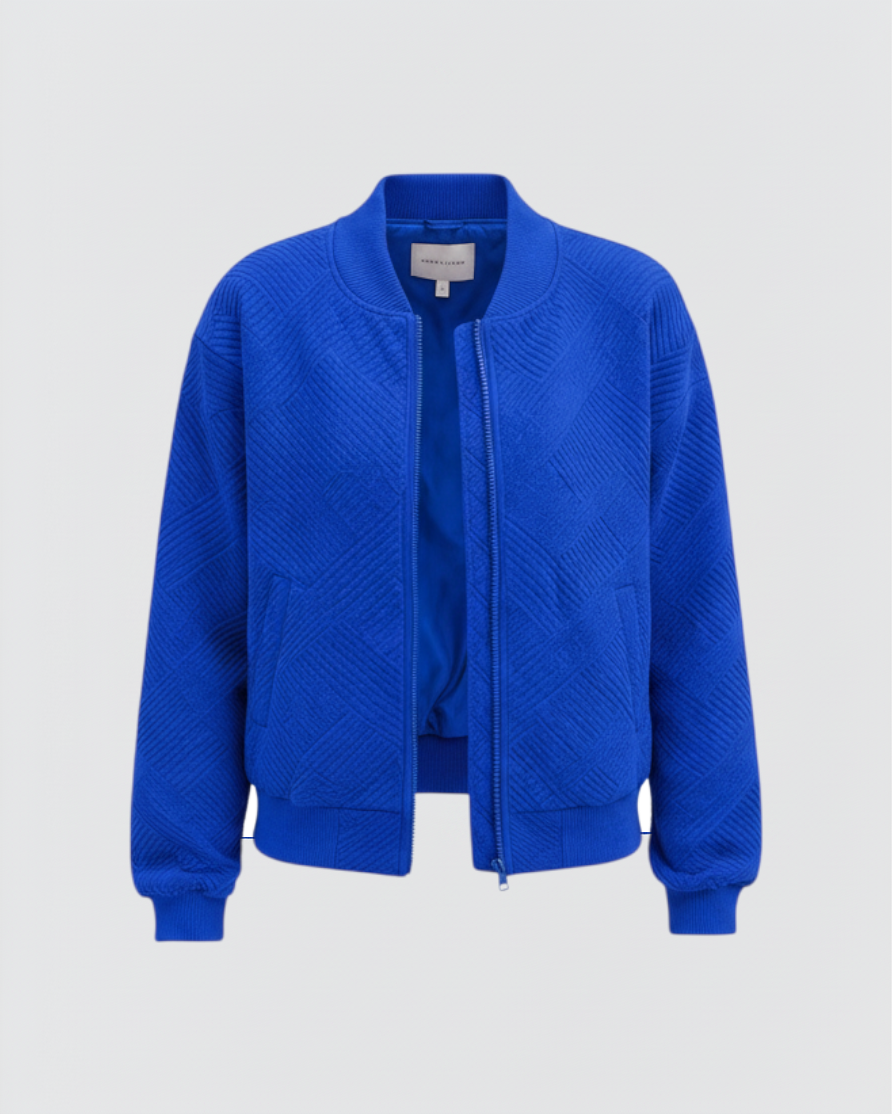 Luna Moda Dora bomber jacket in vibrant blue with a textured geometric pattern, front zip, and ribbed cuffs.