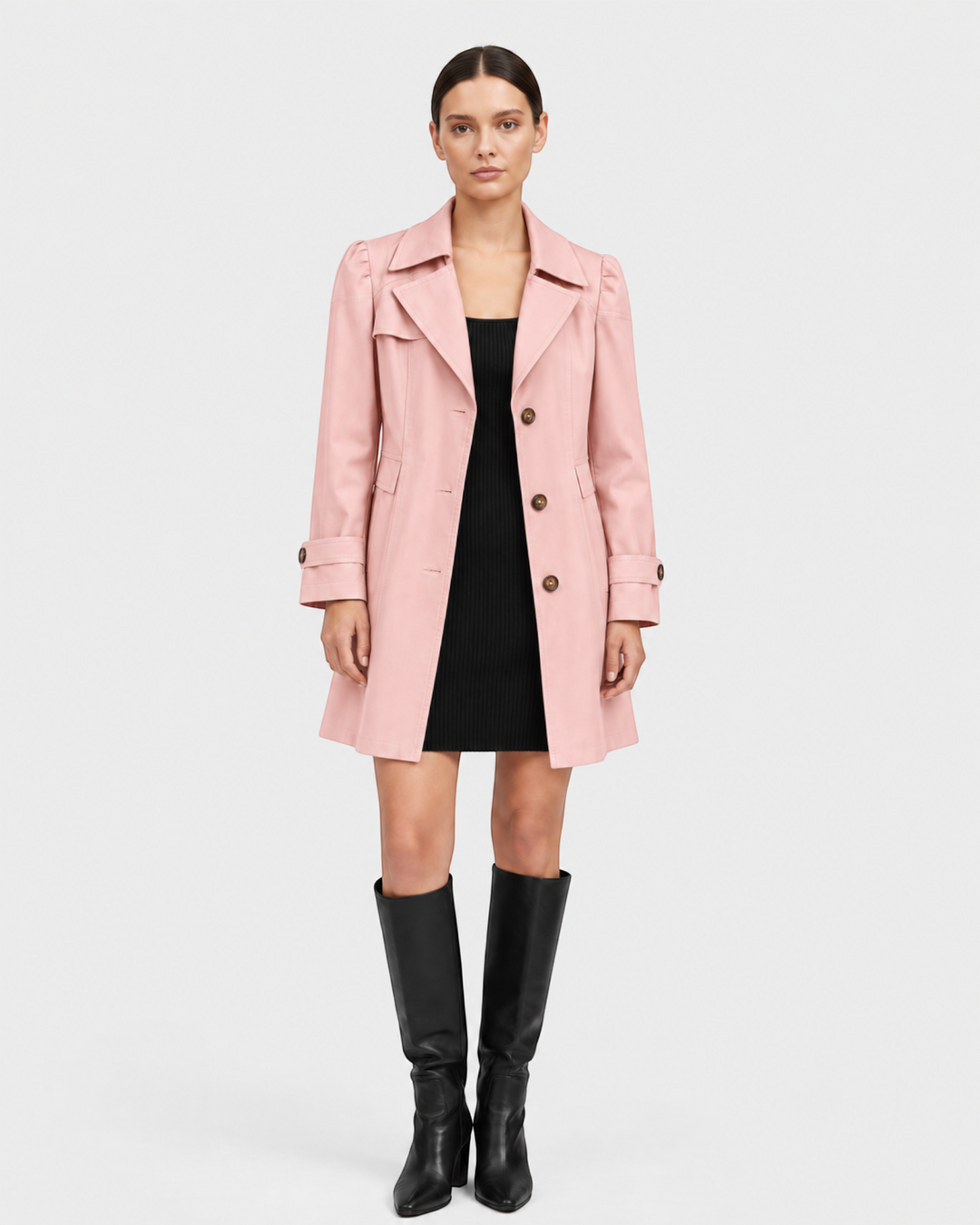 Luna Moda light pink flared trench coat in gabardine fabric worn by a model over a black dress and knee-high boots.