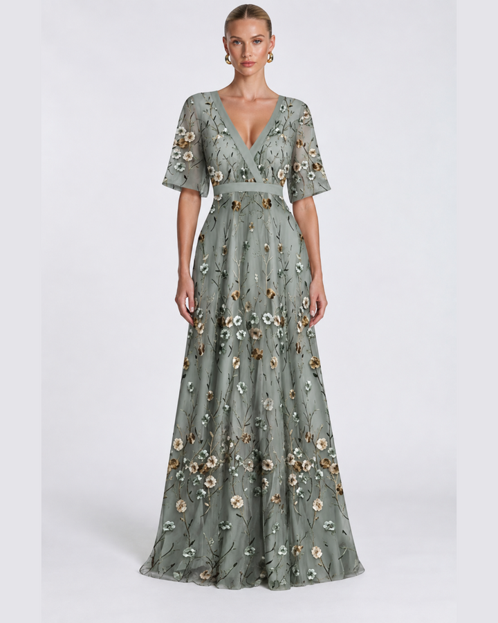 Luna Moda long sage green evening dress with V-neck, short sleeves, and delicate floral embroidery on sheer fabric.