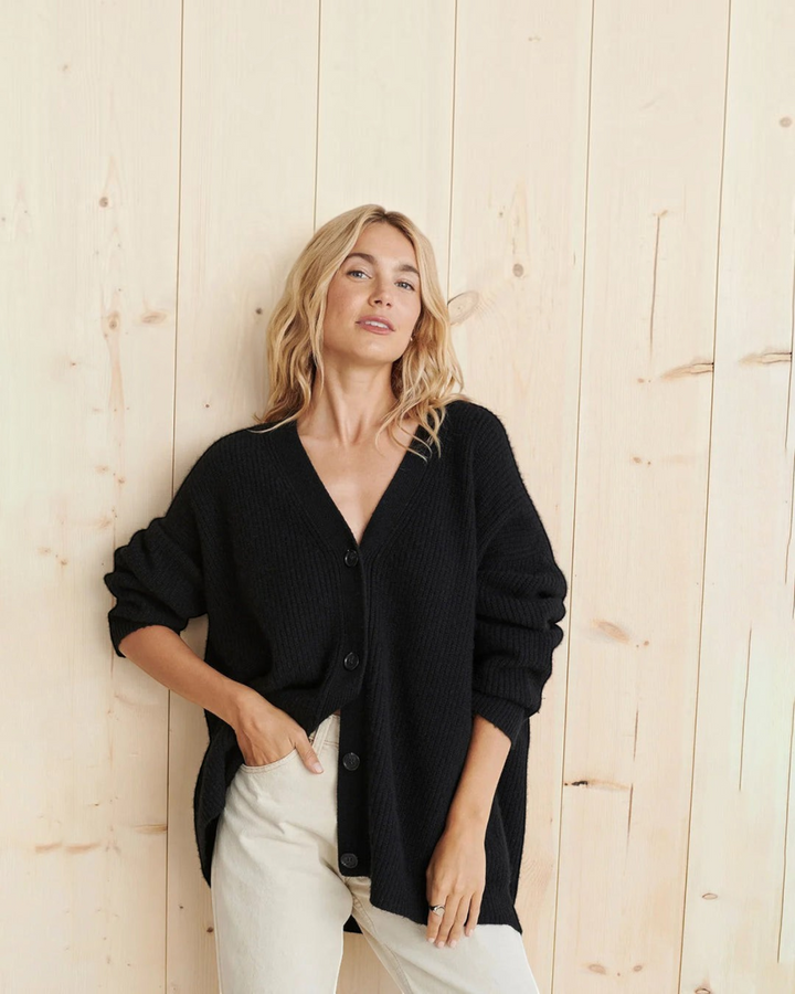 Luna Moda black cashmere V-neck cardigan worn by a woman against a light wood wall