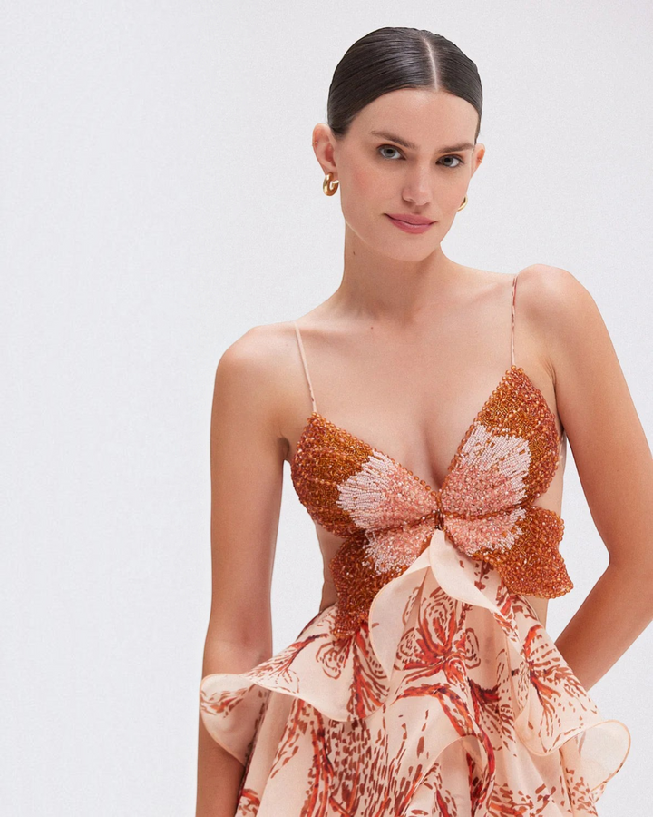 Luna Moda Nahia dress with butterfly-shaped beaded bodice and ruffled skirt in soft peach and orange tones