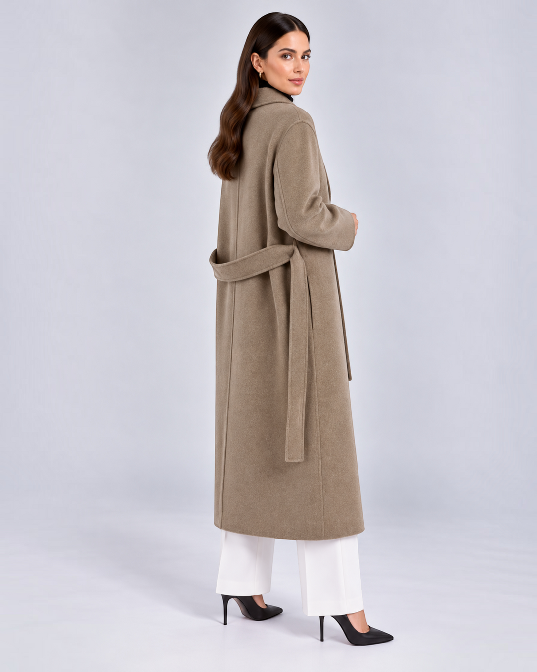 Luna Moda long taupe wool-blend coat with a tie belt, worn by a model over white trousers and black heels.