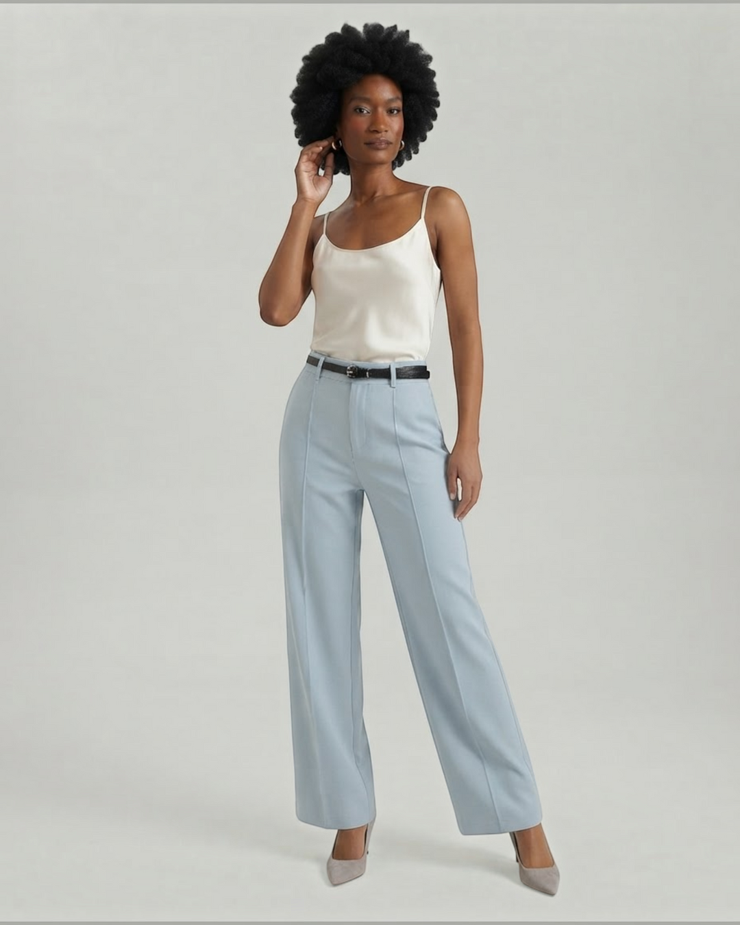Luna Moda light blue palazzo trousers with front pleats and a matching belt worn by a model with a silk camisole.