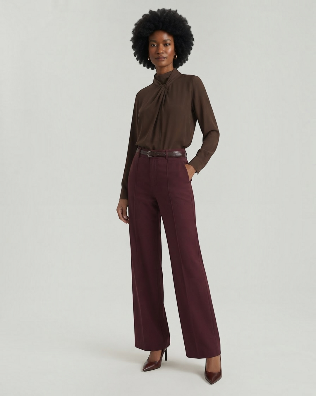 Model wearing Luna Moda burgundy palazzo trousers with front pleats and a matching belt, paired with a brown blouse.