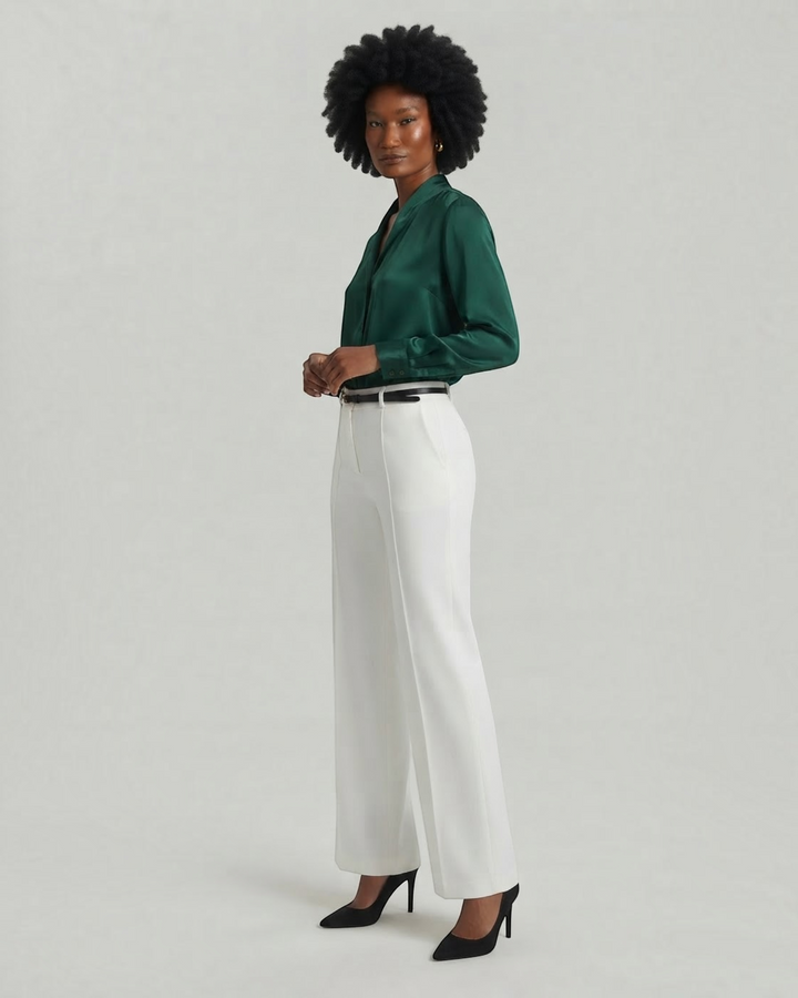 Luna Moda Clotilde white palazzo trousers with front pleats and belt worn by a model with a dark green silk shirt