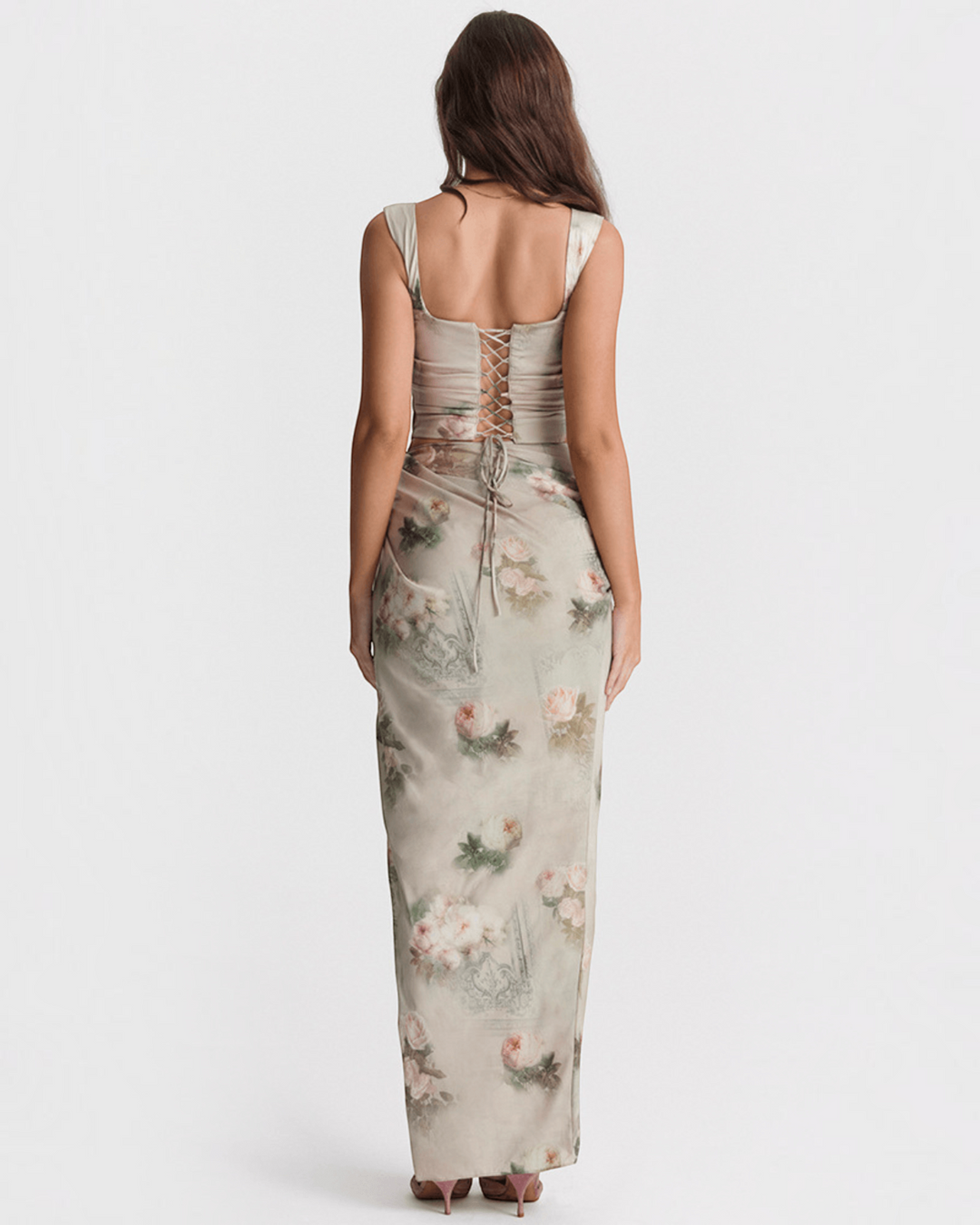 Luna Moda back view of a woman wearing a bronze satin corset top with lace-up detail and a floral print maxi skirt.