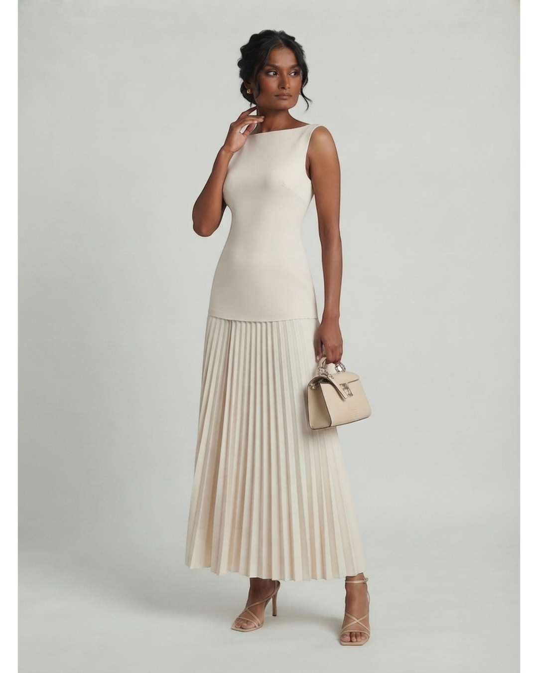 Luna Moda Celeste sleeveless maxi dress in cream with a structured bodice and elegant pleated skirt on a model.