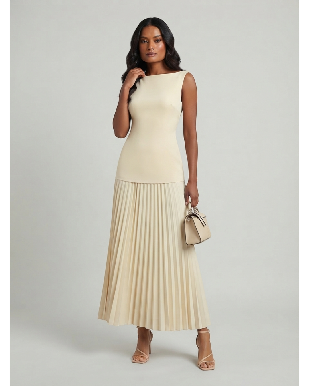 Luna Moda Celeste maxi dress in cream with a sleeveless structured bodice and a flowing pleated skirt on a model.