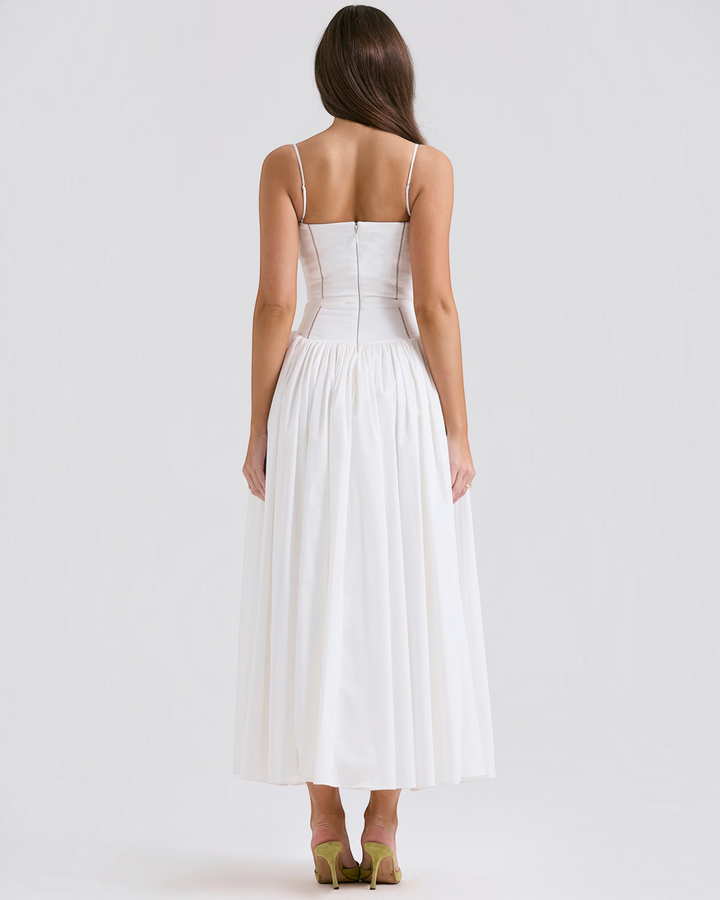 Back view of a model wearing a Luna Moda white midi dress with a fitted bodice and spaghetti straps.