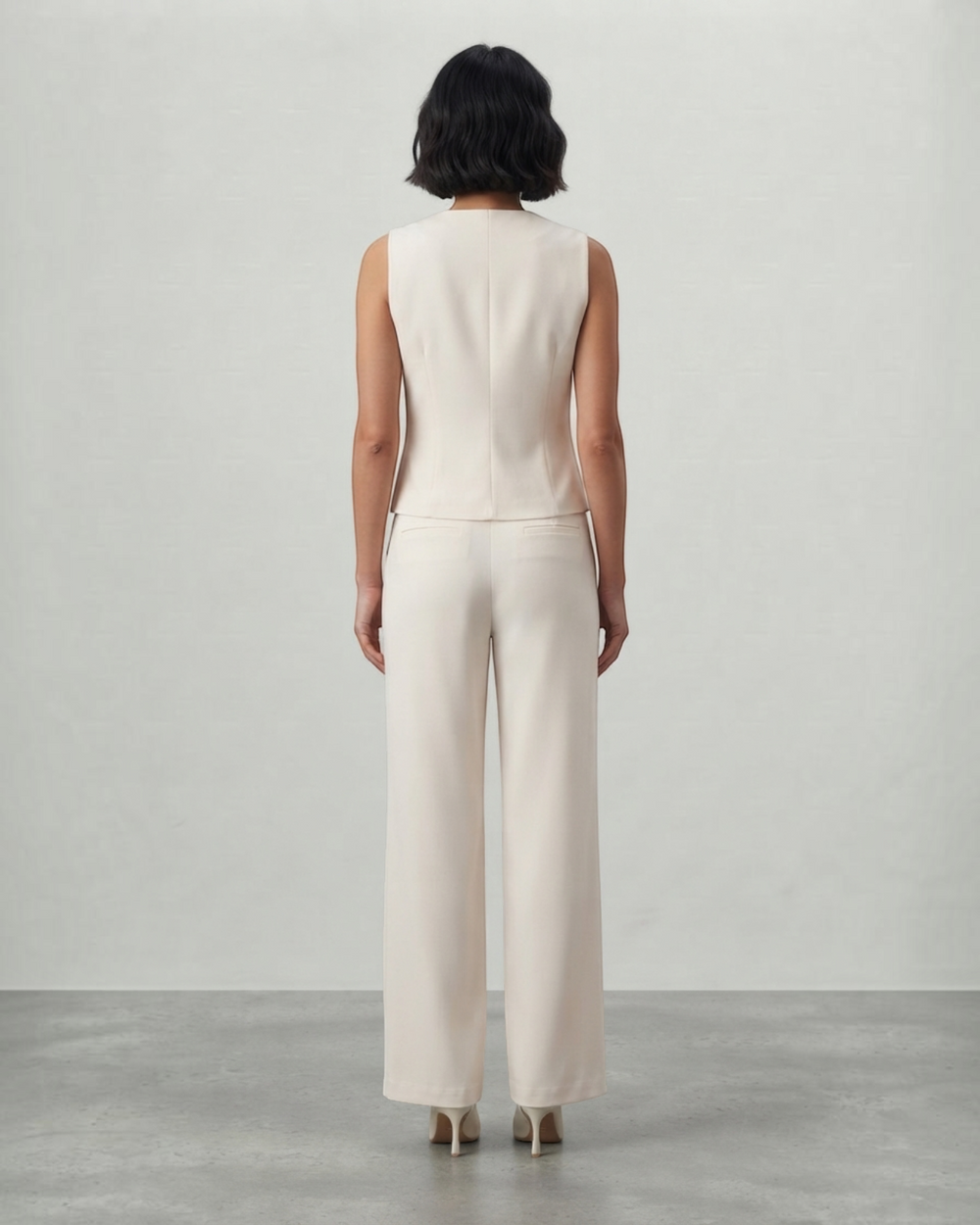 Luna Moda cream sleeveless top and tailored trousers set worn by a woman, back view showing a sleek silhouette.
