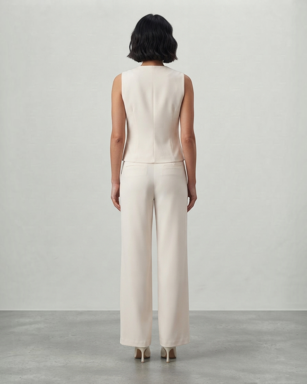 Luna Moda cream sleeveless top and tailored trousers set worn by a woman, back view showing a sleek silhouette.