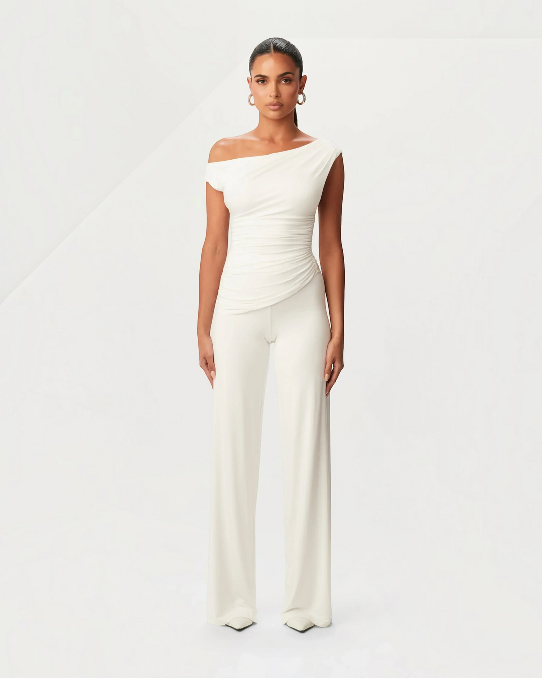 Luna Moda white asymmetric top and matching trousers set with side ruching on a model against a neutral background