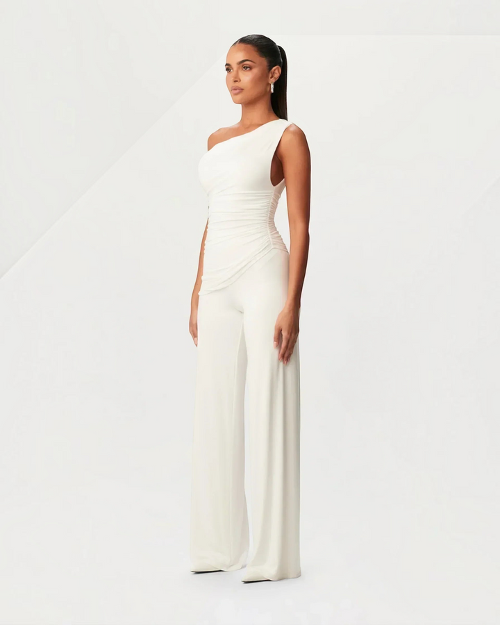 Luna Moda white asymmetrical one-shoulder jumpsuit with side ruching worn by a model in a studio setting