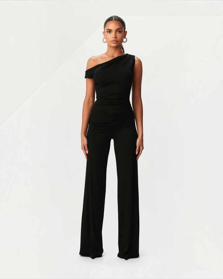 Luna Moda black asymmetrical jumpsuit with side ruching worn by a model against a plain studio background
