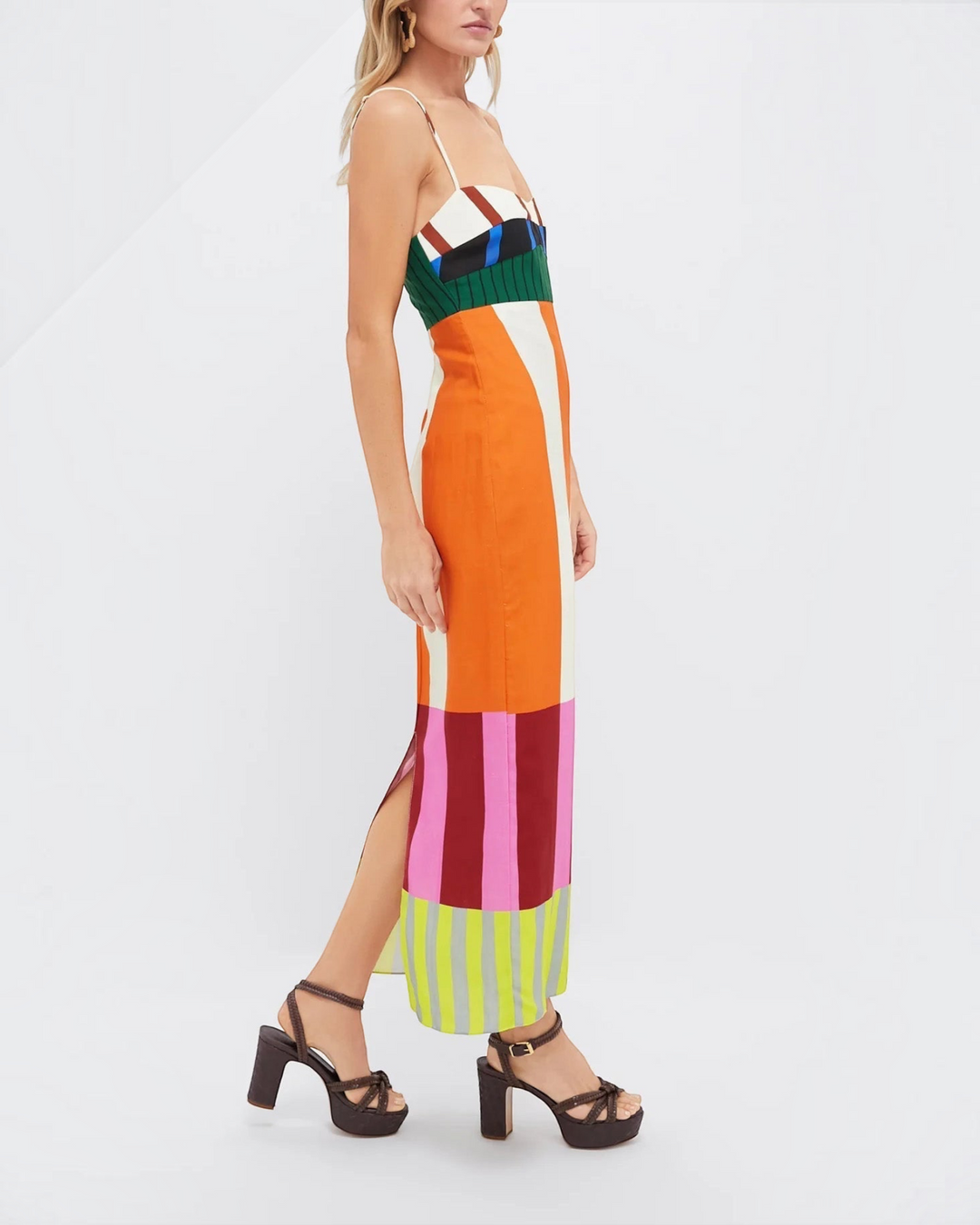 Luna Moda Paloma maxi dress with vibrant geometric stripes, empire waist, thin straps, and side slit on a model.
