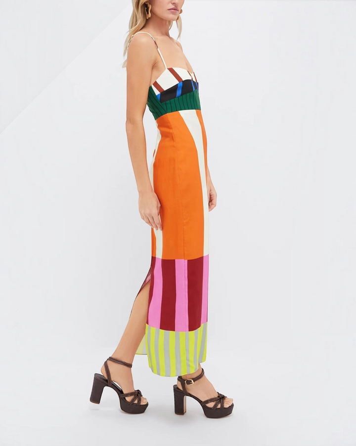 Luna Moda Paloma maxi dress with vibrant geometric stripes, empire waist, thin straps, and side slit on a model.