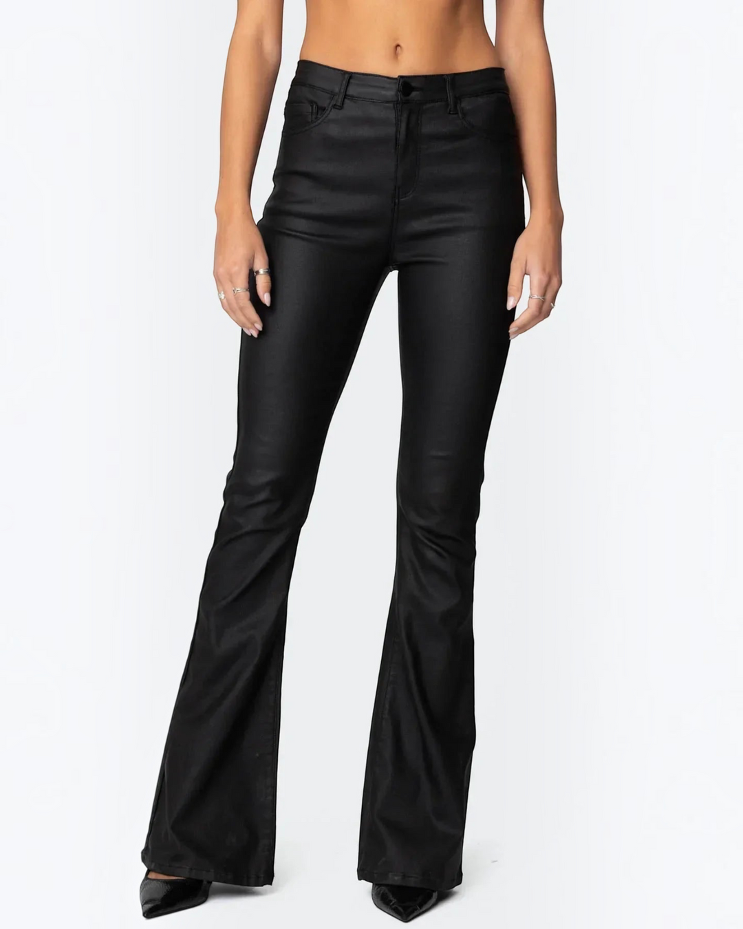 Luna Moda ELENA high-waisted black glossy flared trousers worn by a model, creating a sleek and elongated silhouette.