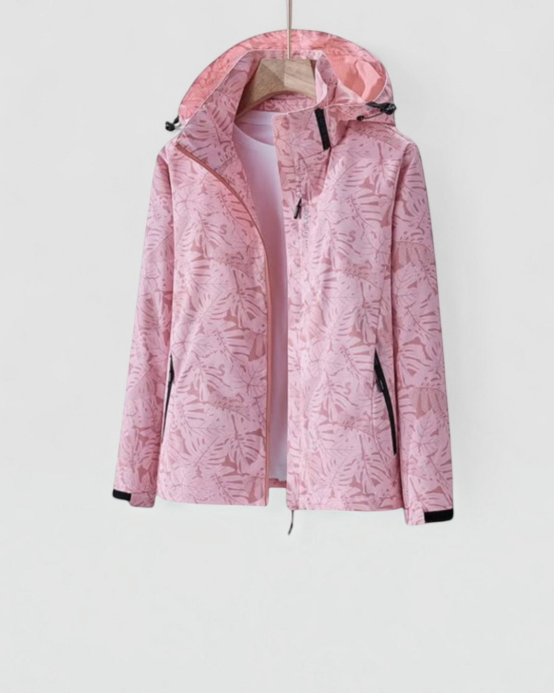 Luna Moda lightweight waterproof jacket in light pink with a tropical leaf print, featuring a hood and zip closure.