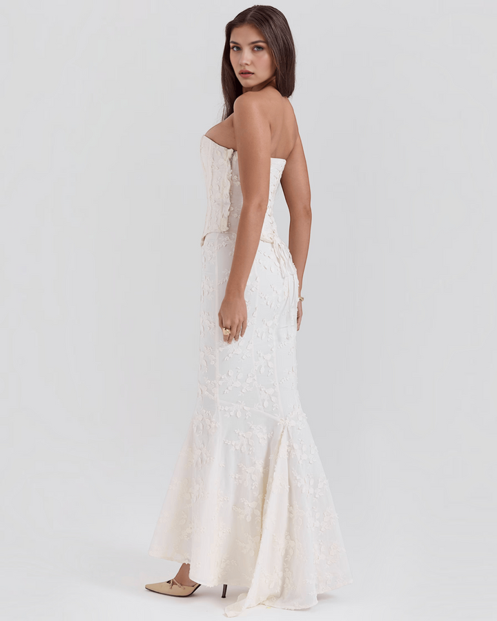 Luna Moda ivory floral embroidered corset dress with a flared hem worn by a model in a side profile view