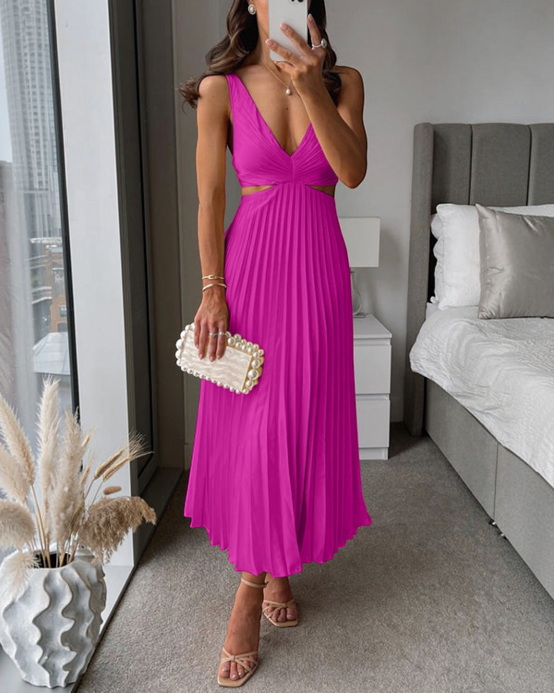Luna Moda Abito Bellezza fuchsia pleated maxi dress with side cutouts and a deep V-neckline worn by a woman.