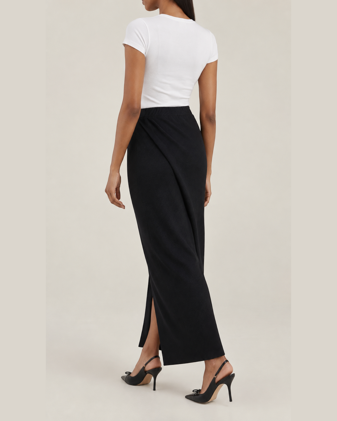 Luna Moda black midi knit wrap skirt worn by a model with a white t-shirt and black slingback heels, back view