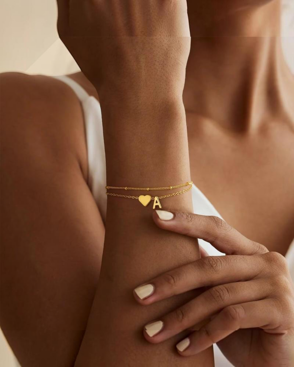 Luna Moda gold double chain bracelet featuring a minimalist heart charm and a personalized initial letter pendant