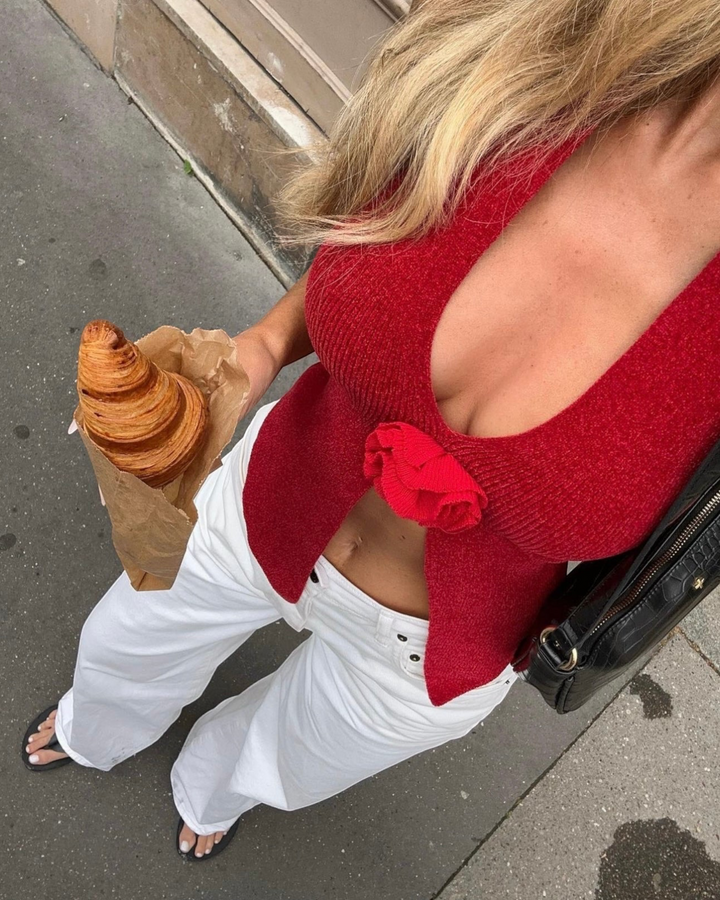 Luna Moda EVA red ribbed knit top with a rose detail, worn with white wide-leg trousers for a chic street style look.