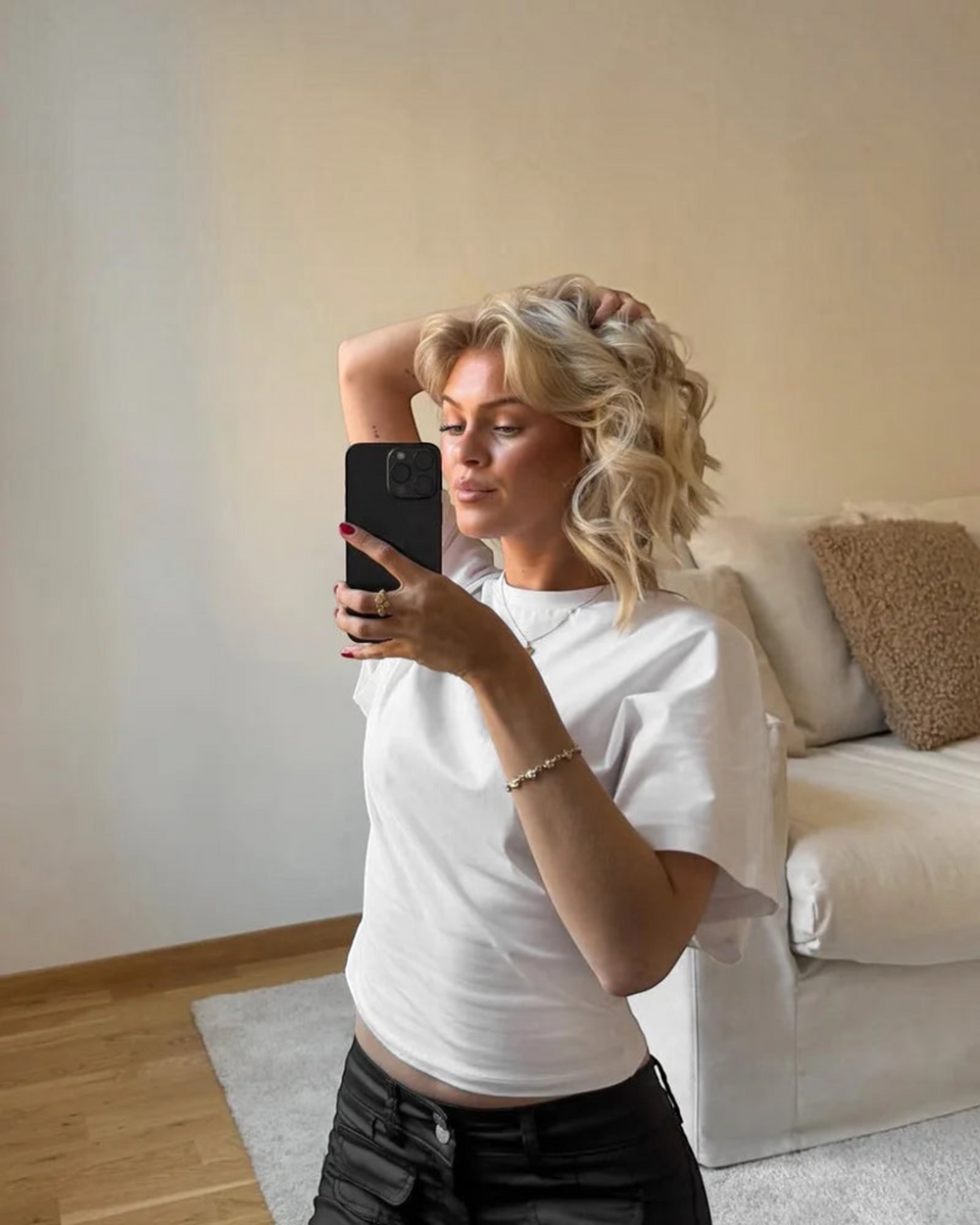Luna Moda Stella white relaxed fit t-shirt worn by a woman taking a mirror selfie in a bright living room