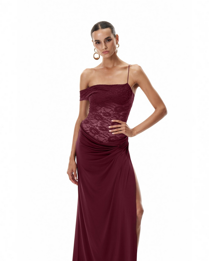 Luna Moda burgundy one-shoulder maxi dress with a semi-sheer lace bodice, draped skirt, and high thigh slit.