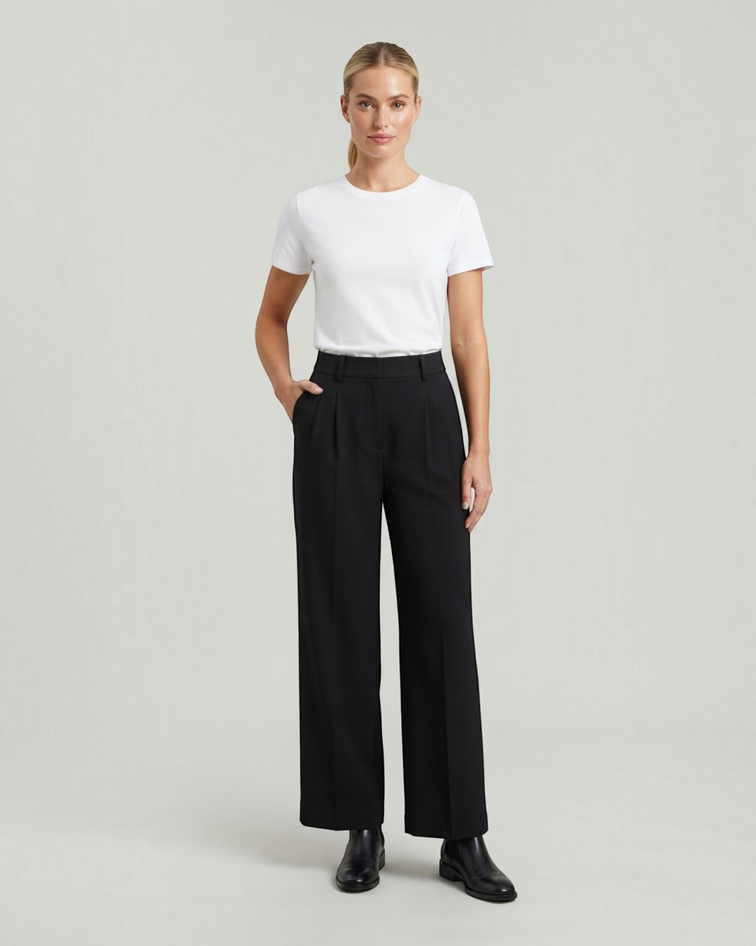 Luna Moda high-waisted black palazzo trousers with pleated details worn by a model with a white t-shirt