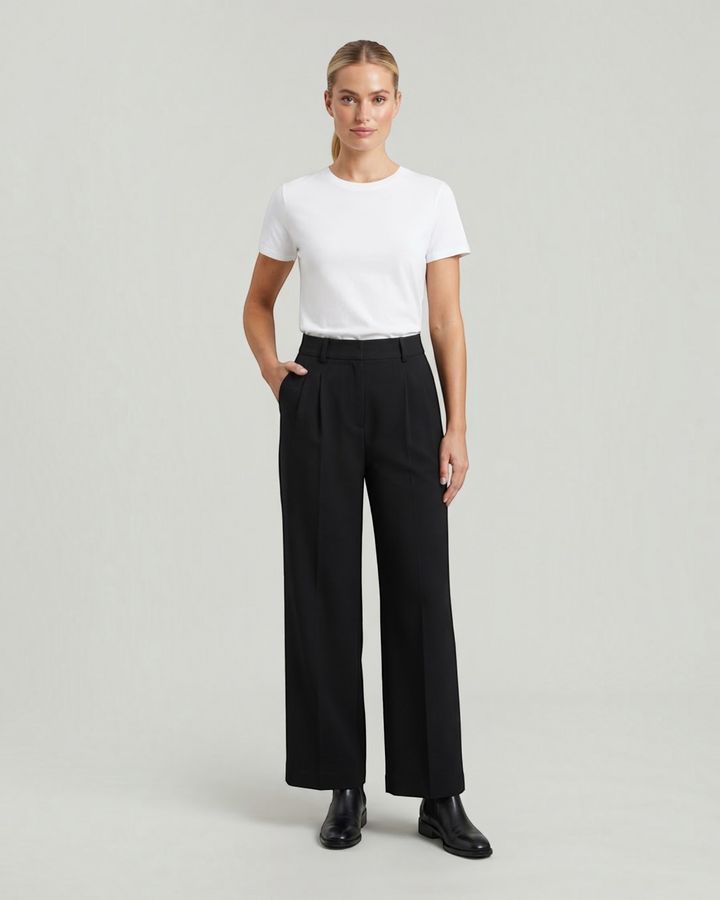 Luna Moda high-waisted black palazzo trousers with pleated details worn by a model with a white t-shirt