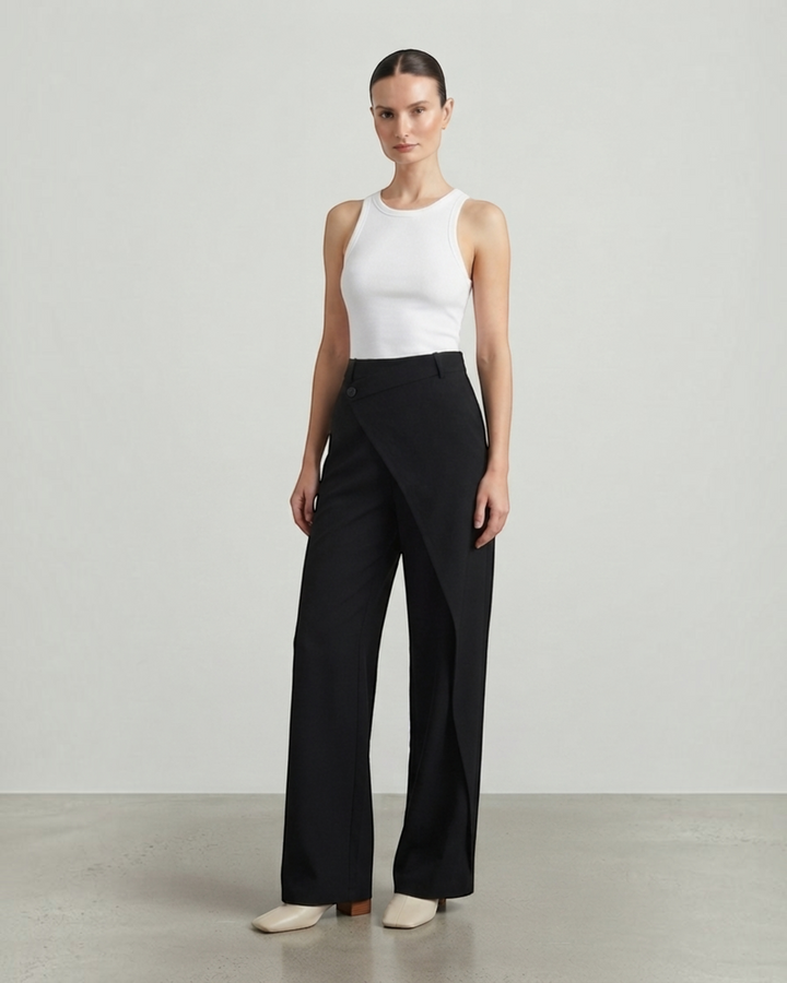 Luna Moda Licia black wide-leg trousers featuring an asymmetric overlapping front panel and button detail.