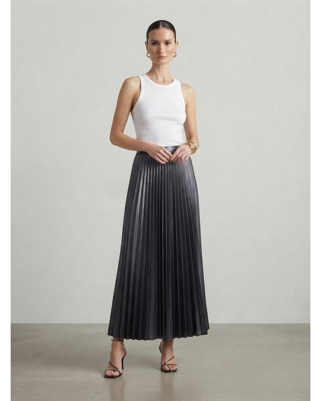 Luna Moda high-waisted charcoal grey pleated maxi skirt worn by a model with a white tank top and strappy heels.
