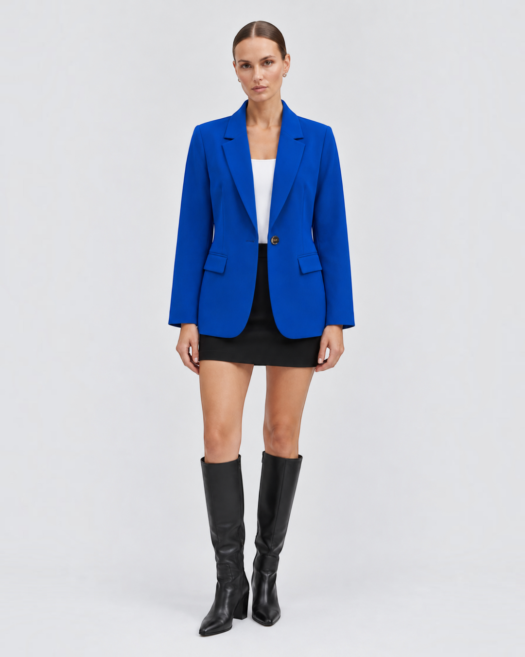 Luna Moda Mirella classic royal blue blazer worn by a model with a white top, black mini skirt, and knee-high boots.