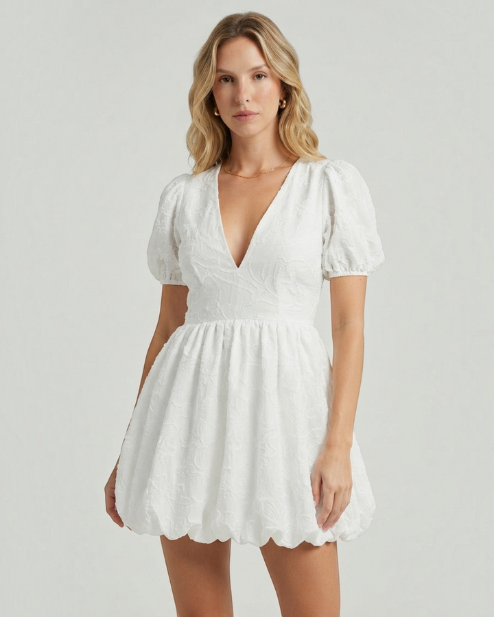 Luna Moda white mini dress with puff sleeves, V-neckline, and delicate embroidery worn by a blonde model