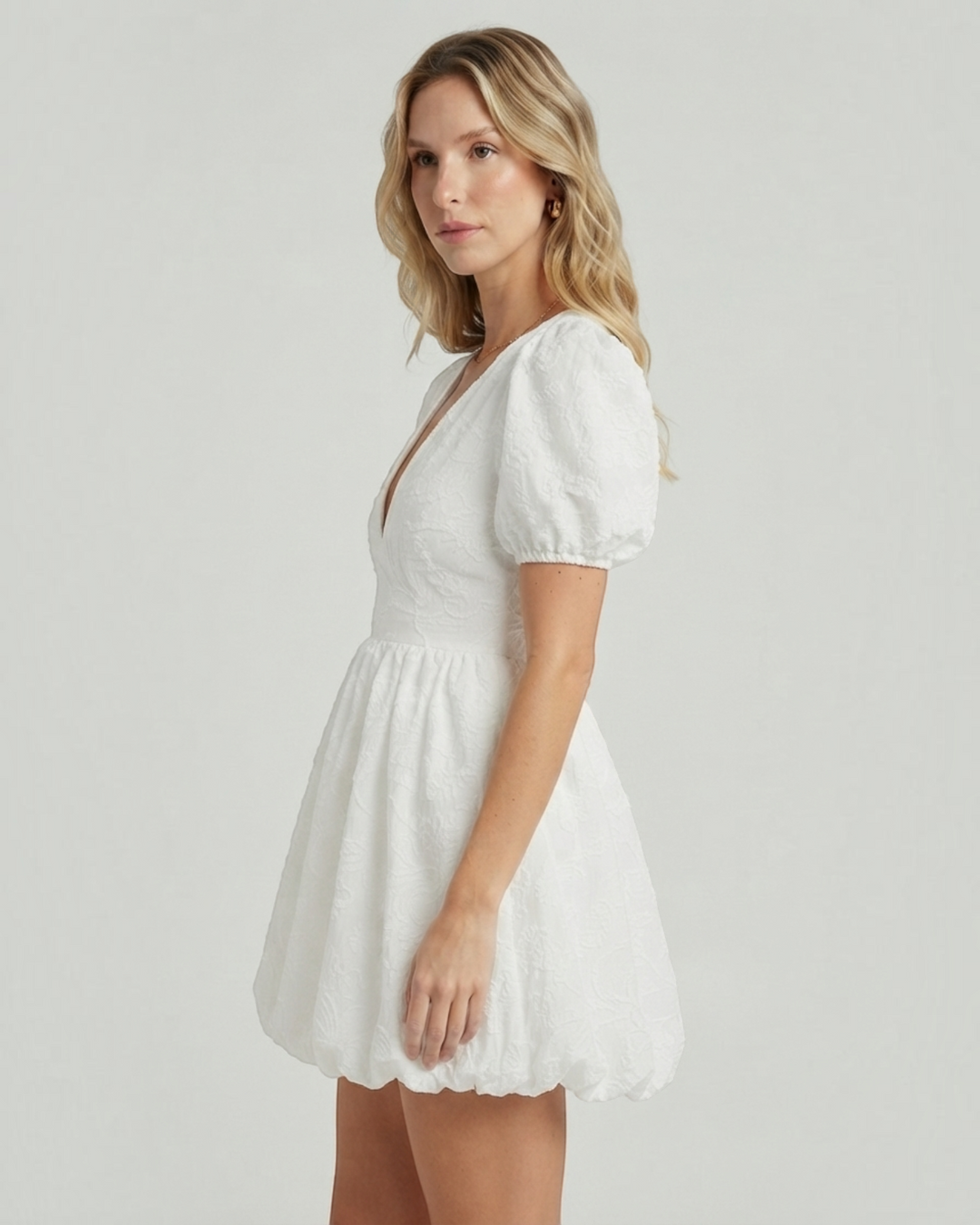 Luna Moda white mini dress with puff sleeves, V-neckline, and delicate embroidery worn by a blonde model