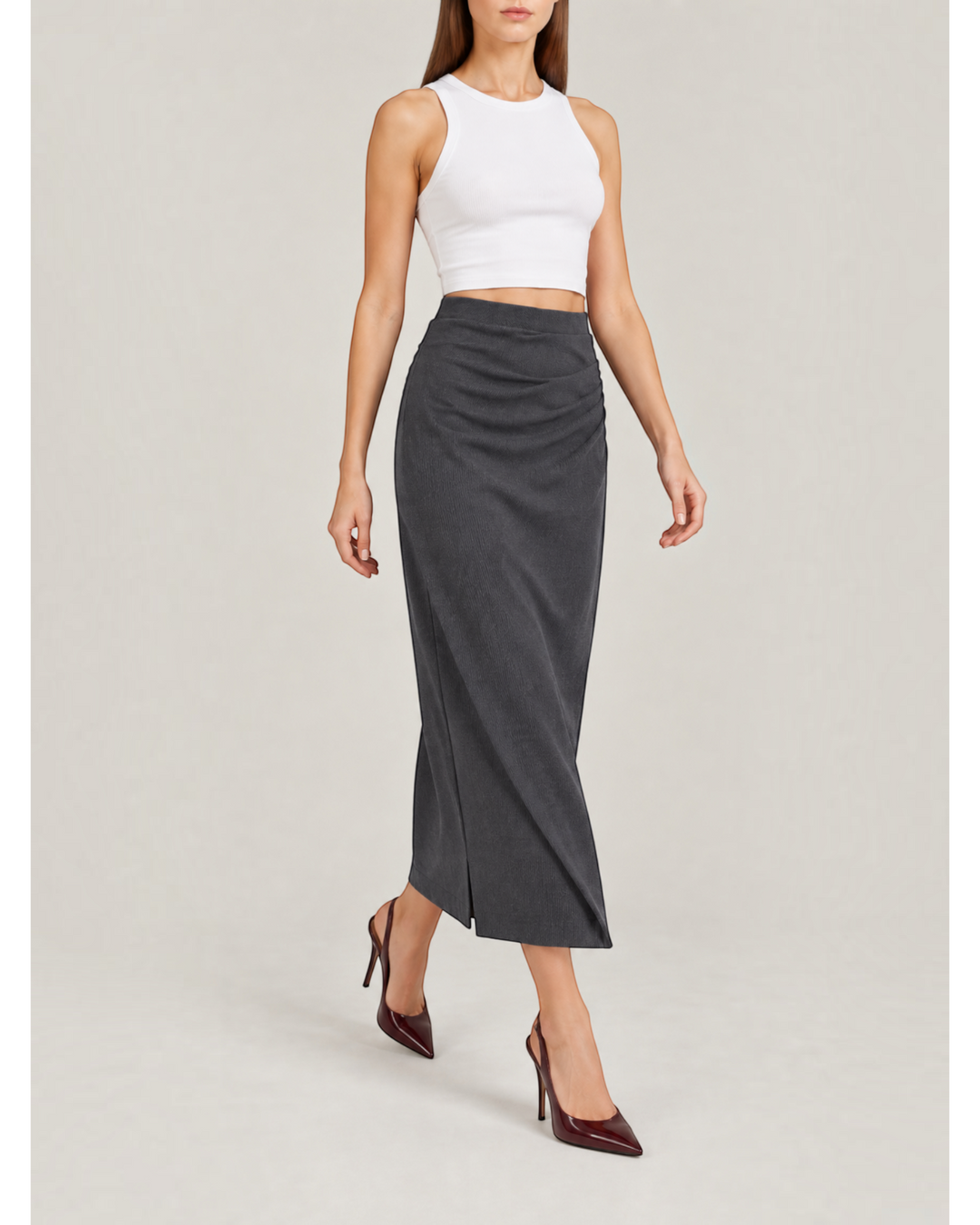 Luna Moda midi skirt in dark grey with side ruching detail, worn by a model with a white tank top and heels.