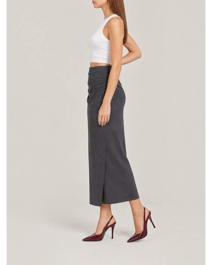 Luna Moda midi skirt in dark grey with side ruching, worn by a model with a white crop top and burgundy heels.