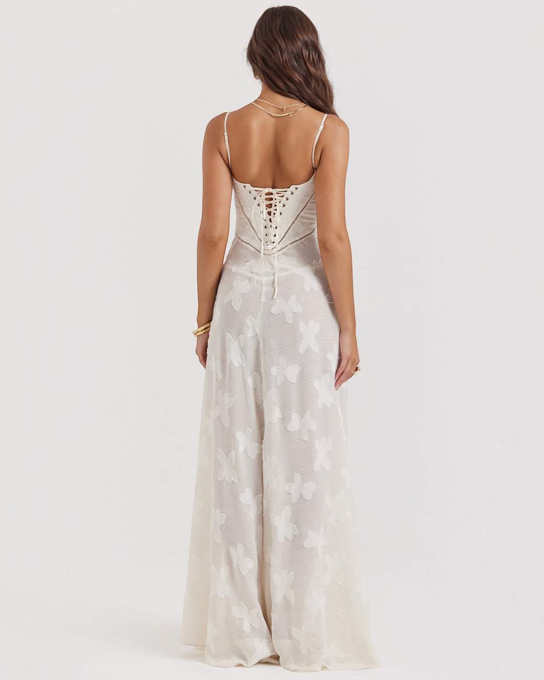 Luna Moda off-white maxi dress with butterfly patterns, lace-up back, and spaghetti straps on a model, back view.