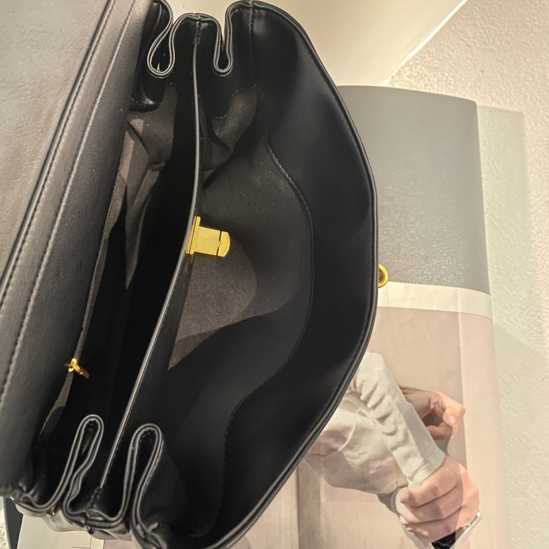 Interior view of Luna Moda RAMONA black leather handbag showing multiple compartments and gold metal clasp hardware.