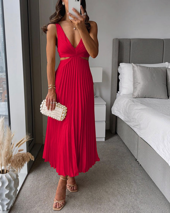 Luna Moda red pleated maxi dress with cut-out waist and v-neckline, styled with a pearl clutch and strappy sandals.