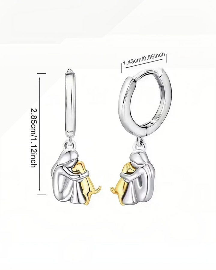 Luna Moda two-tone silver and gold hoop earrings featuring a person hugging a dog charm with measurement details.